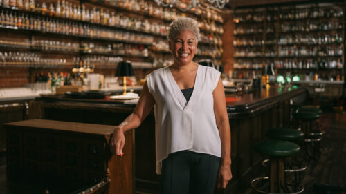 A person stands in front of bar.