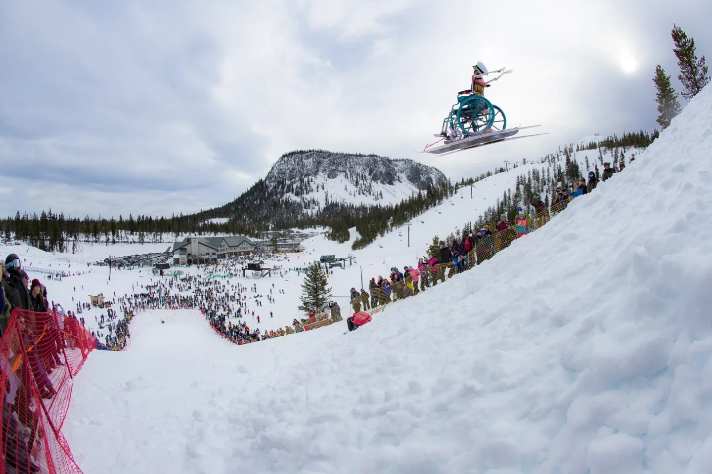 A homemade dummy on skis flies through the air as spectators cheer on at Hoodoo's winter carnival.