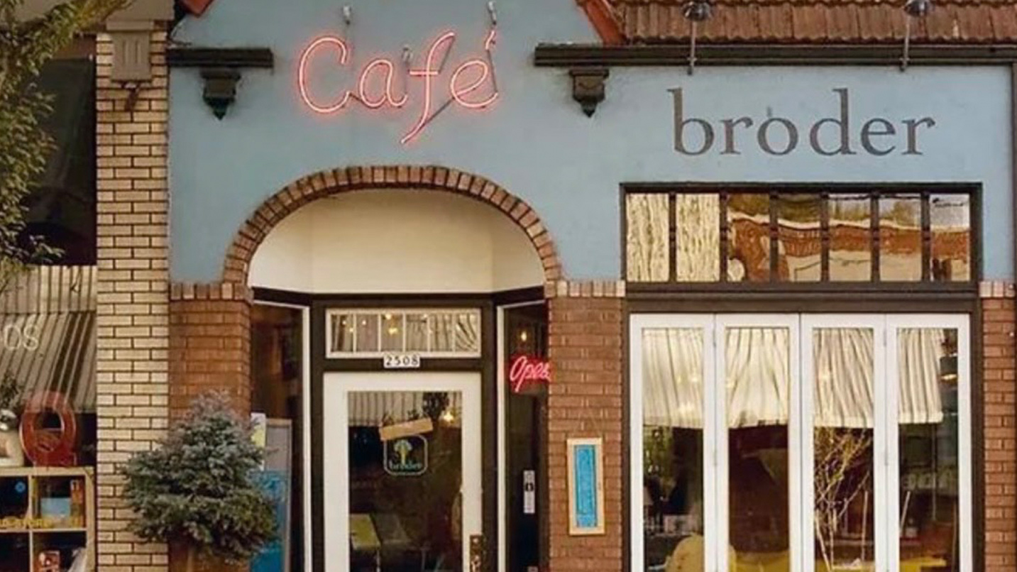 Exterior of brick building cafe with neon sign