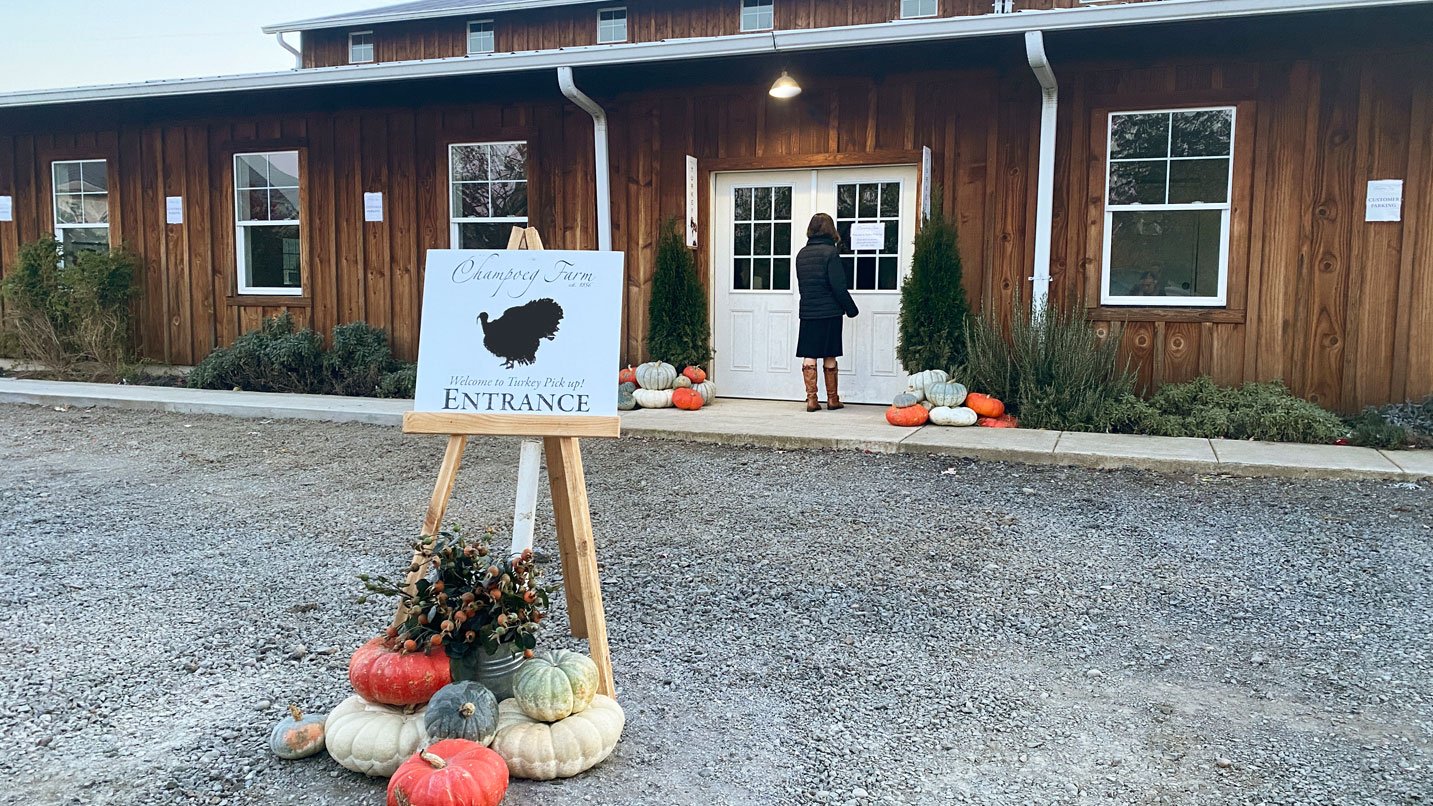 An entrance sign for Champoeg Farm in front of its storefront.
