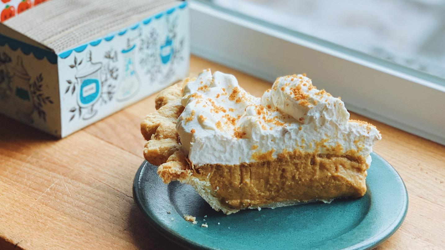 A slice of pumpkin pie with a whipped cream topping.