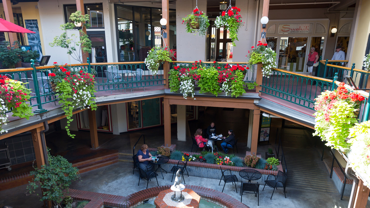 A light- and flower-filled atrium with patio tables.