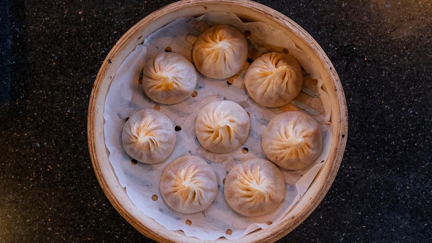 Steamer basket of neatly folded round dumplings
