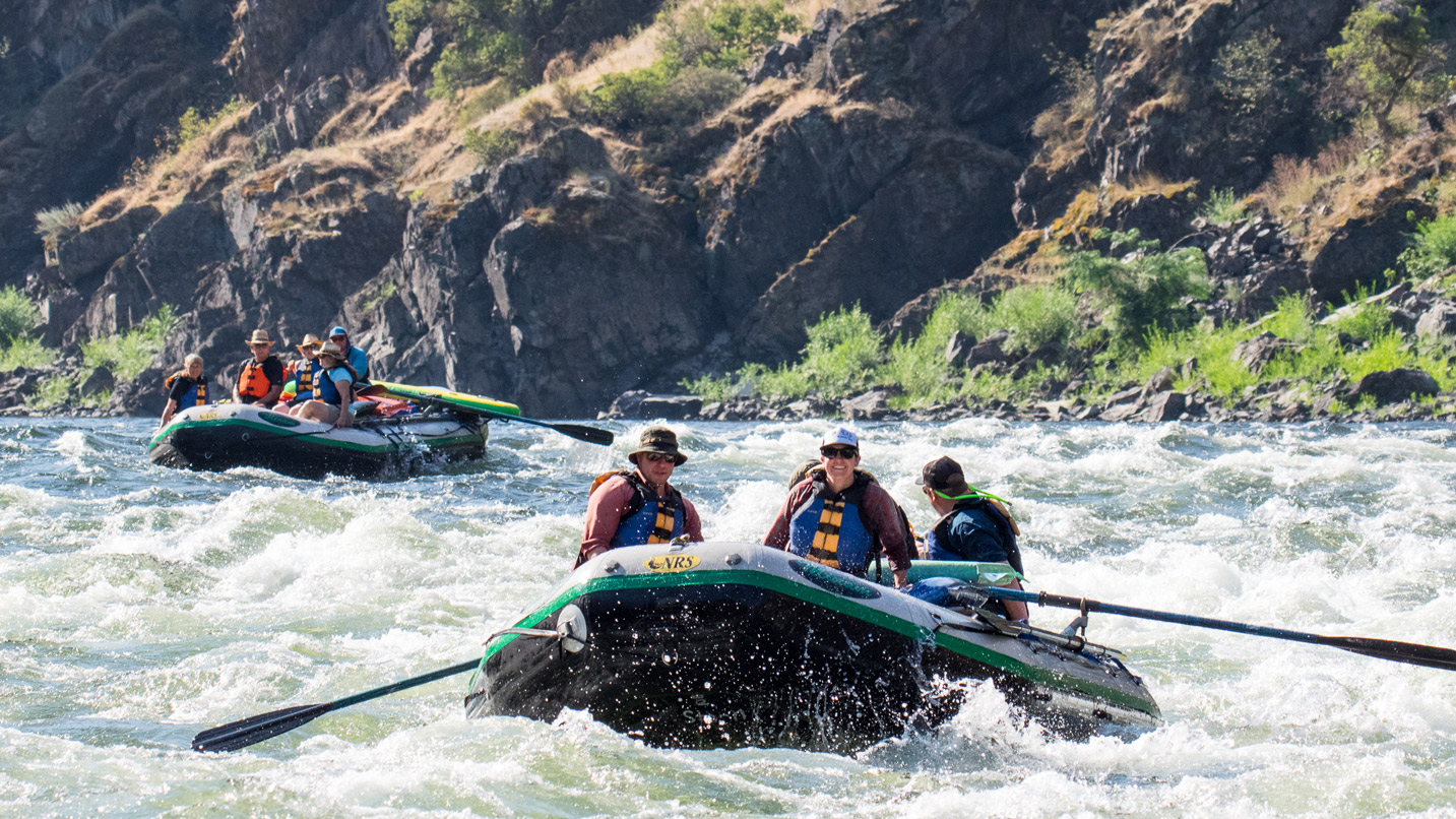 Whitewater rafting through a canyon.