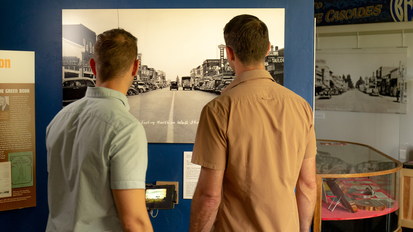 Two people look at a historic photo inside a museum.