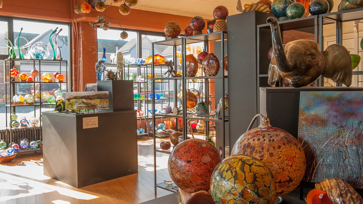 A studio filles with glassbown art in varying colors, sizes and shapes, including a large elephant's head.
