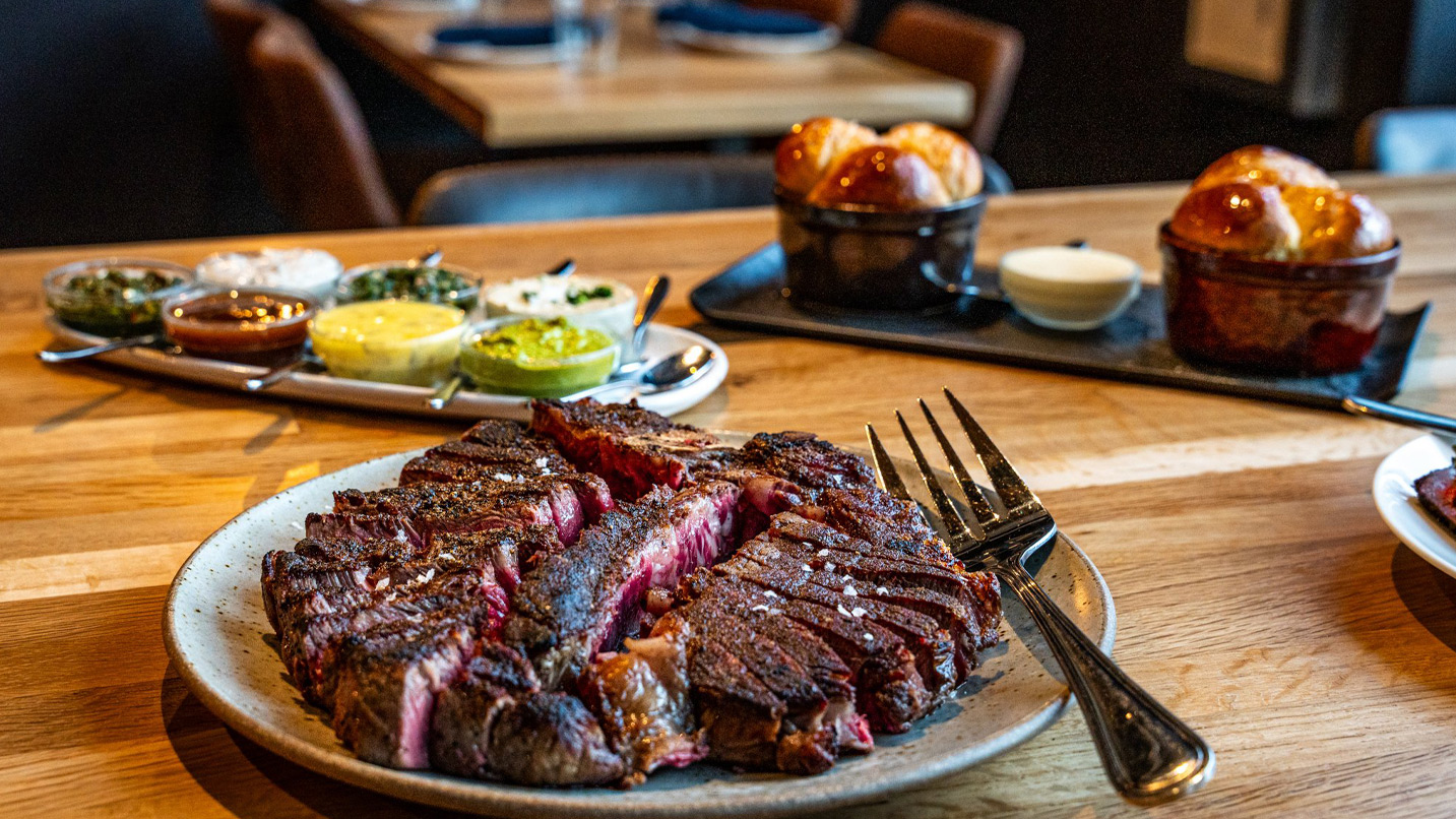 A plate of cut steak on a table.