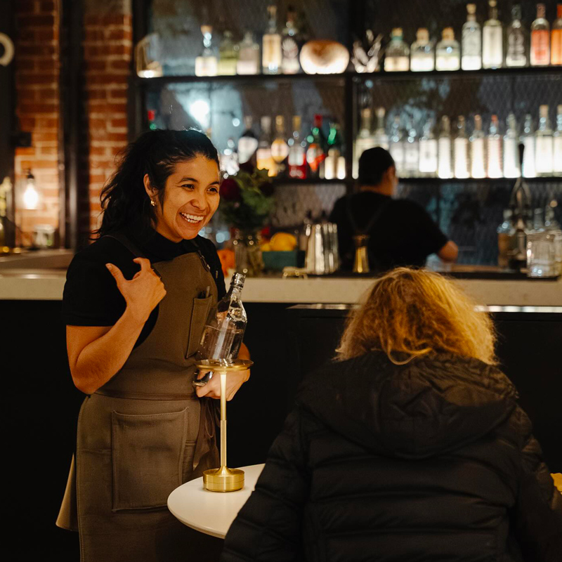 A happy waitress greets a customer.