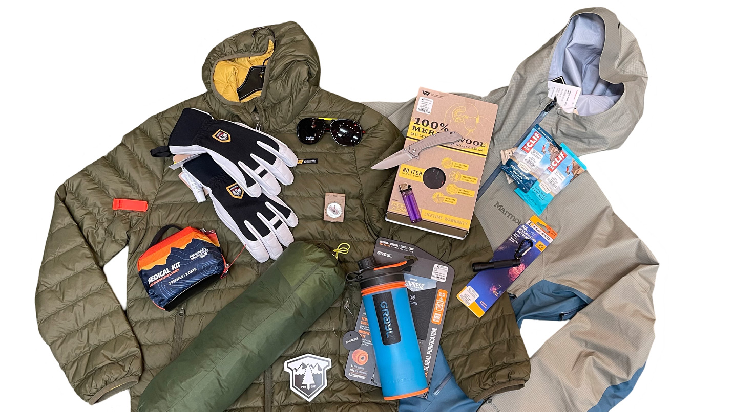 Jackets, gloves, maps, water bottle and first aid kit laid out.