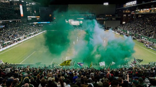 A soccer stadium filled with fans cheering on the Portland Timbers.