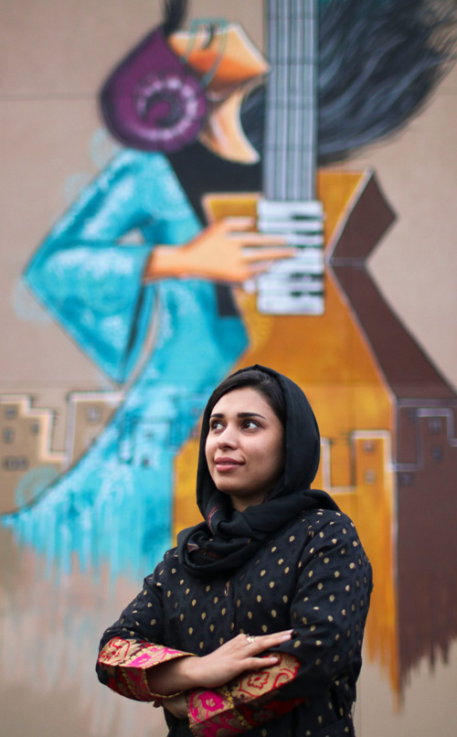 Portrait of the artist in front of her mural.