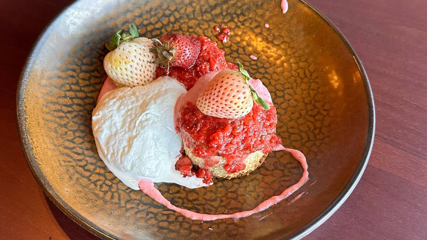 A strawberry shortcake dessert with whipped cream and strawberry jam.