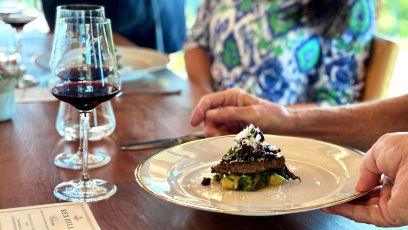 A plate of food and wine on a table.
