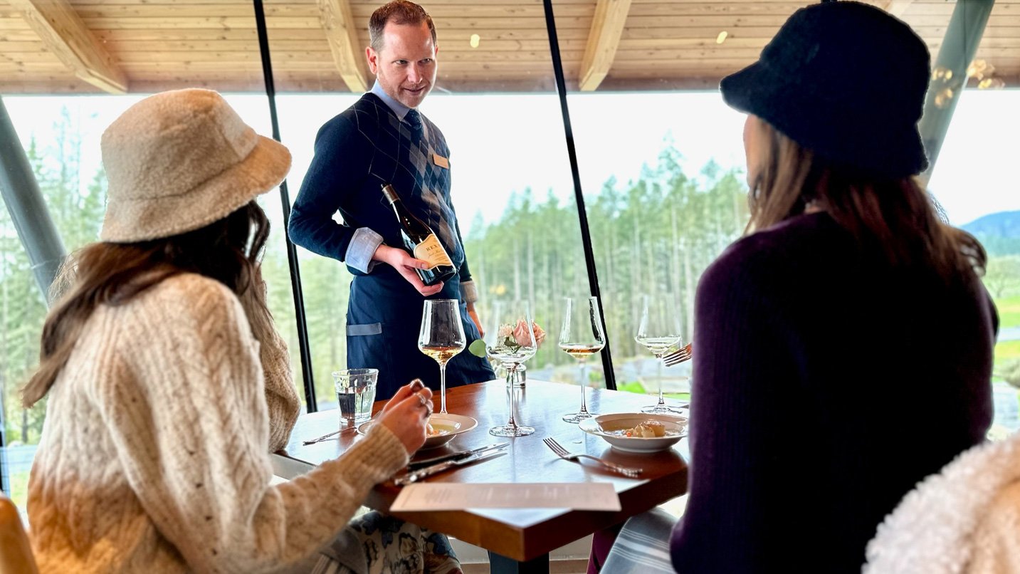 A server holds a bottle of wine.