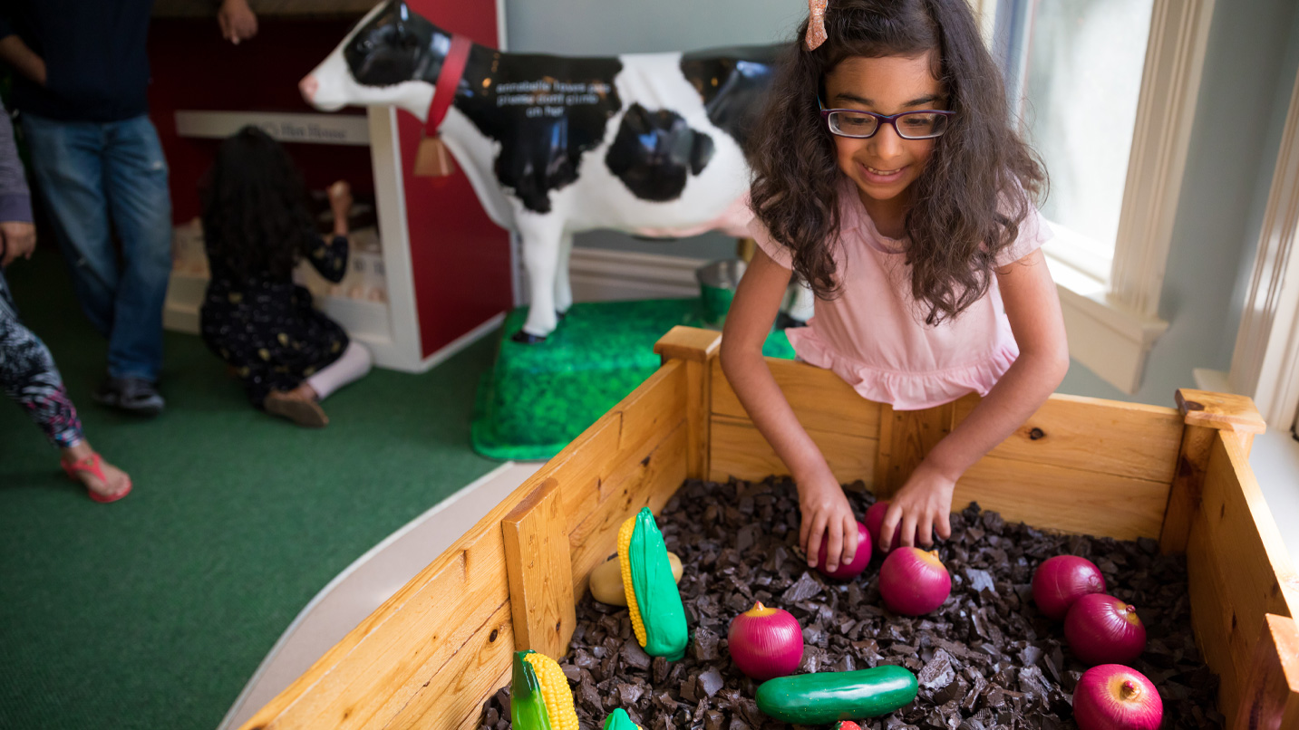 A child plays in a pretend garden.