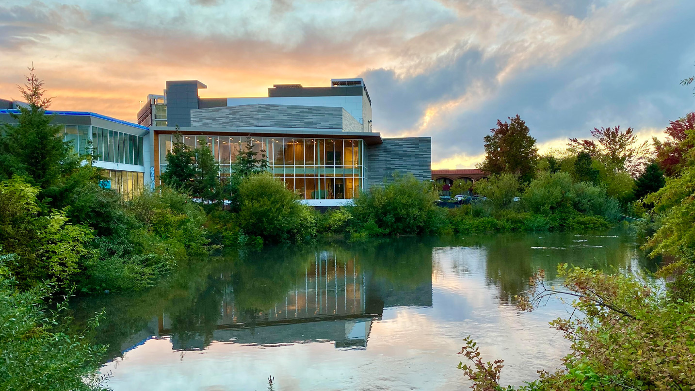 A building sit at the edge of pond.