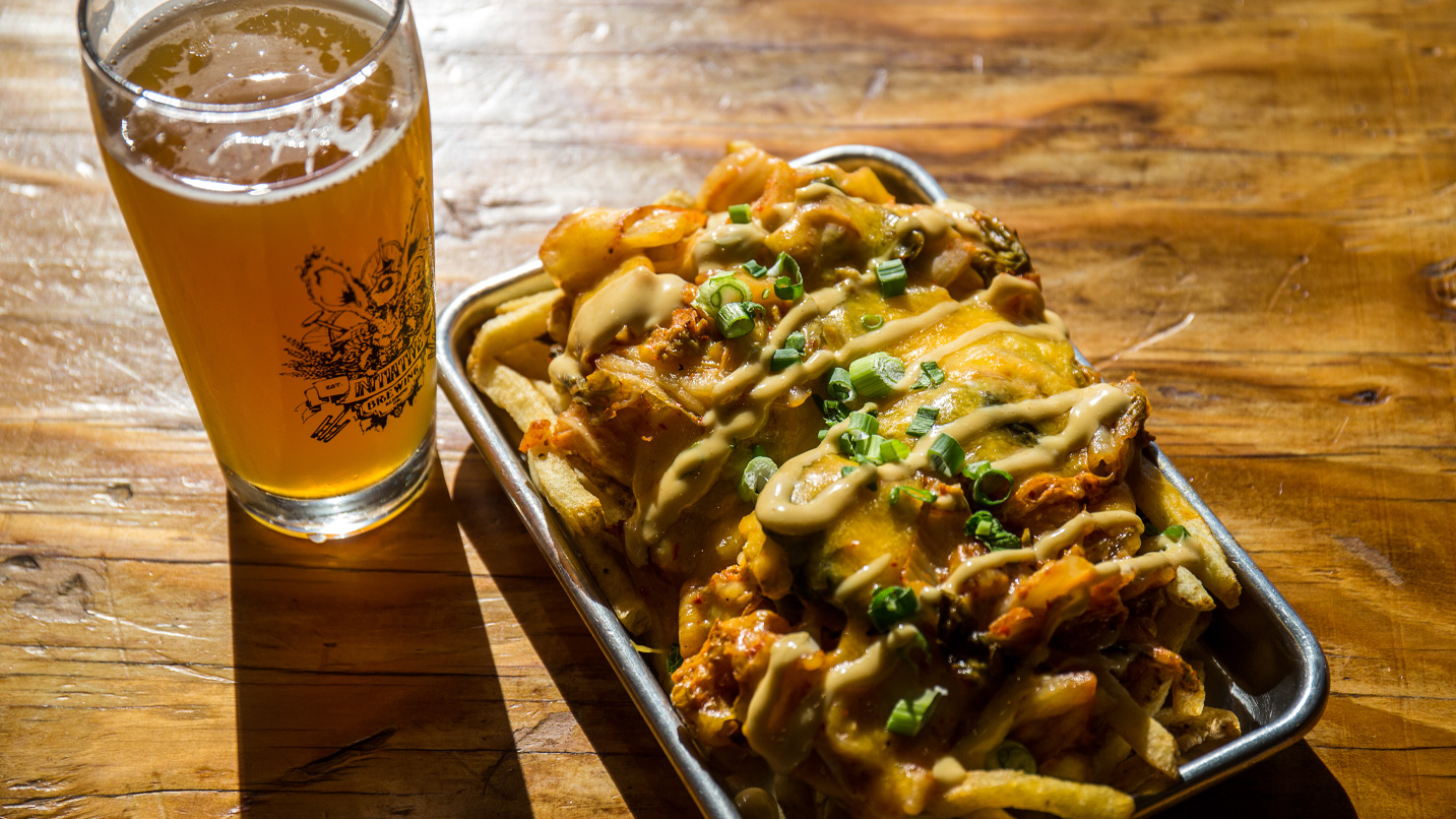 A plate of food and beer on a table.