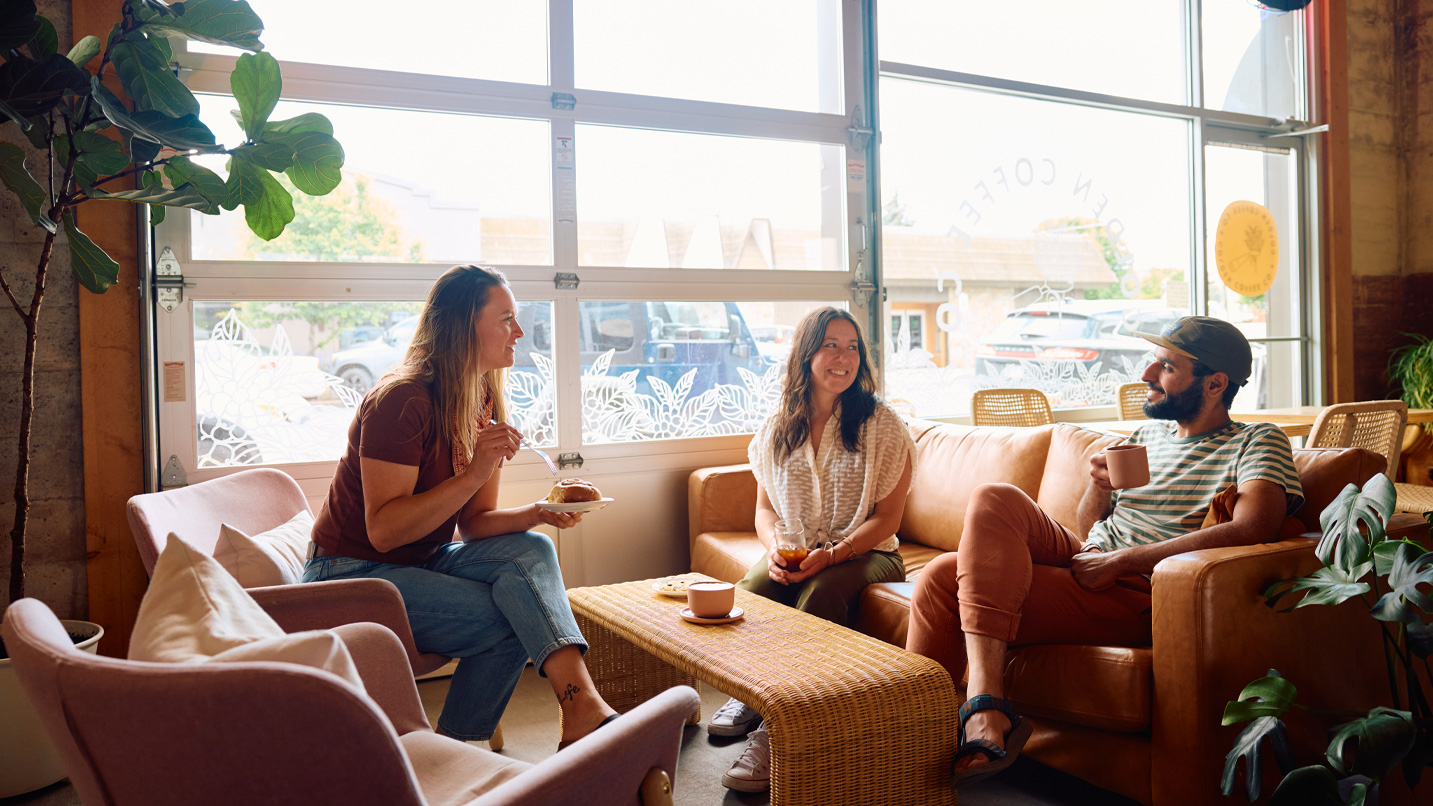 A group of people sitting in sunlit coffee shop.