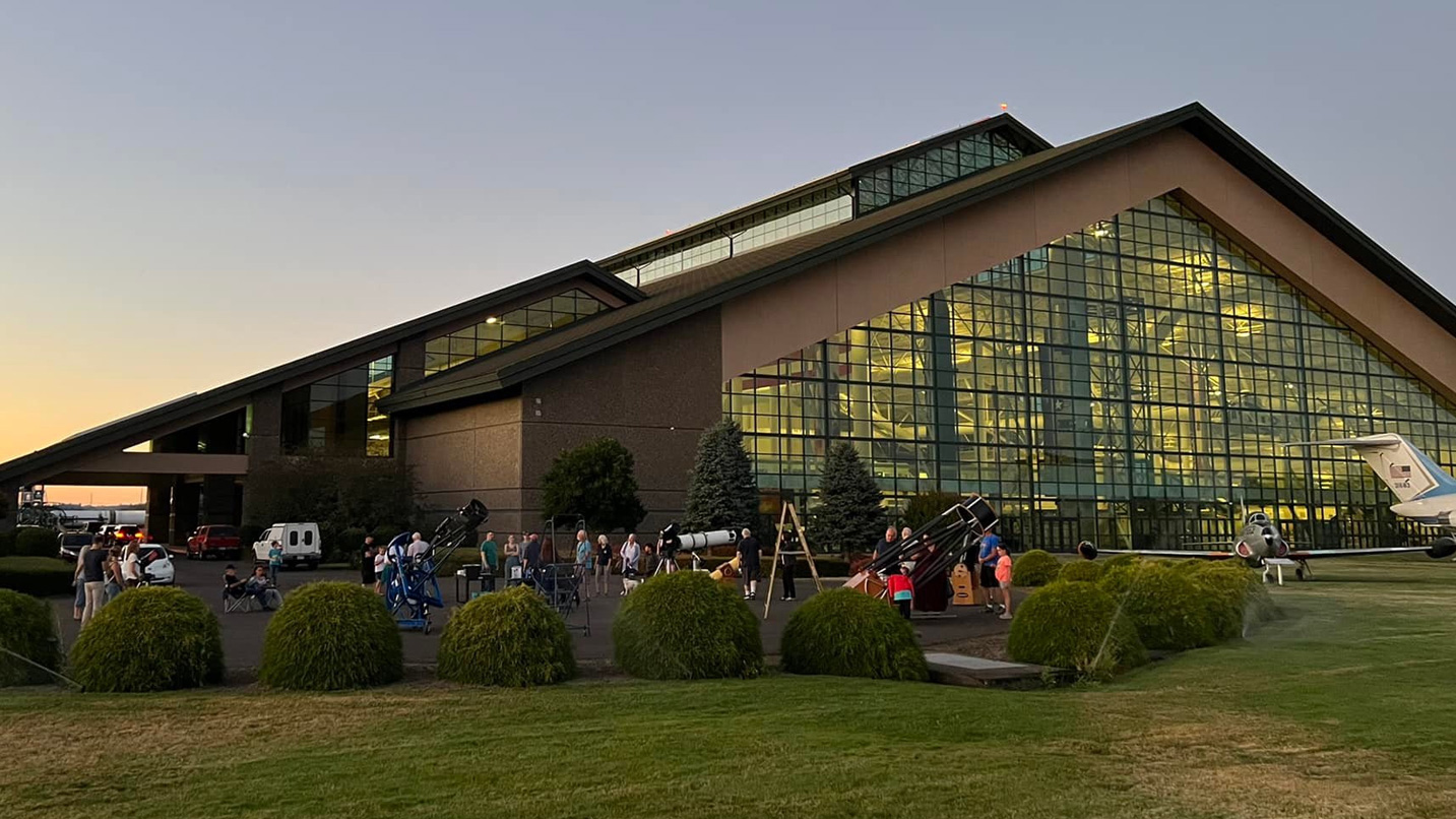 Multiple telescopes set up outside of a museum.
