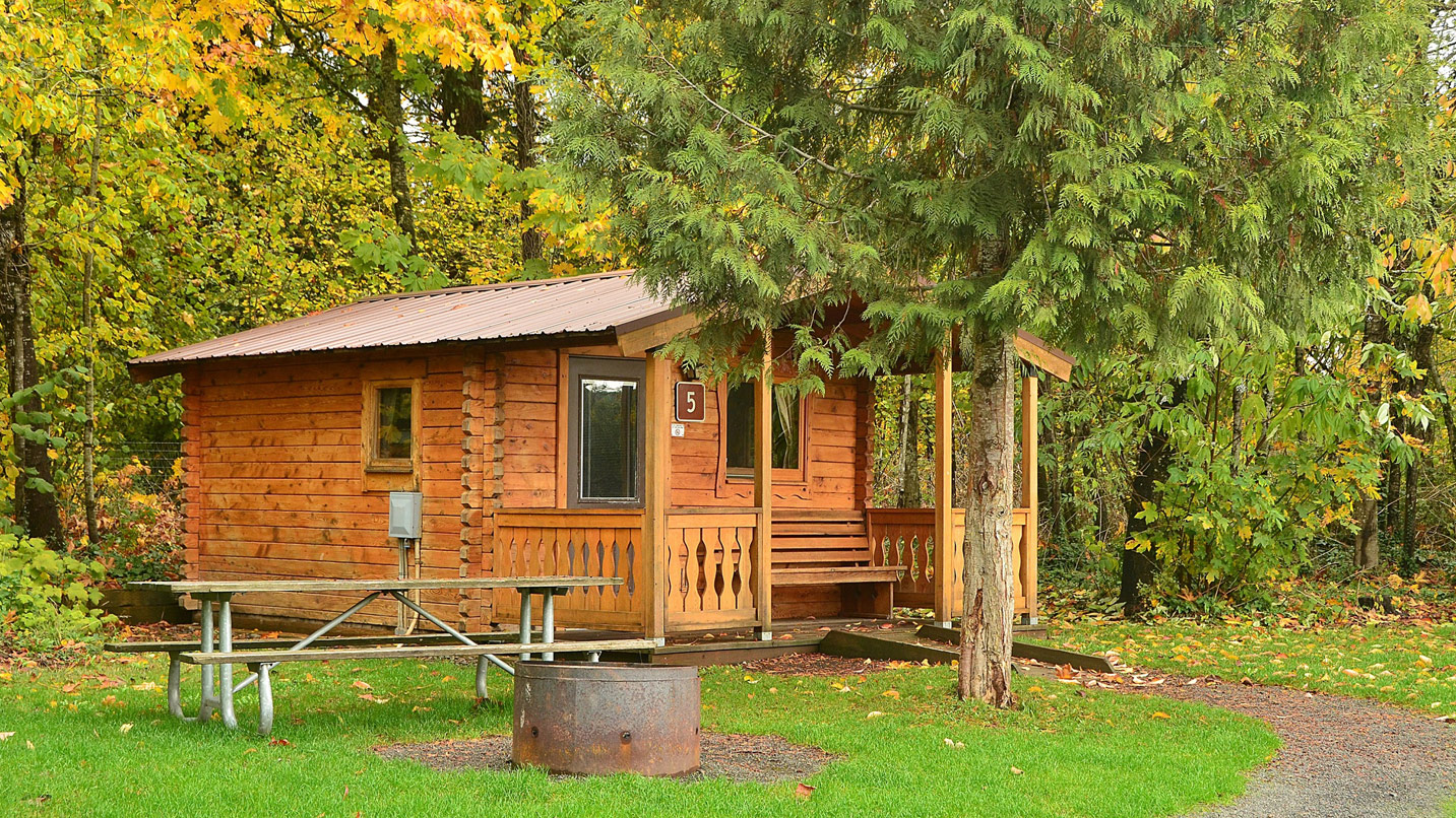 A cabin surrounded by fall foliage.