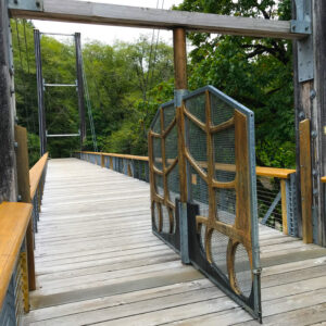 A wood-adorned gate on a pedestrian bridge.