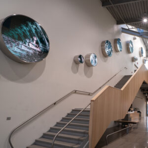 Round pieces of artwork follow a staircase.