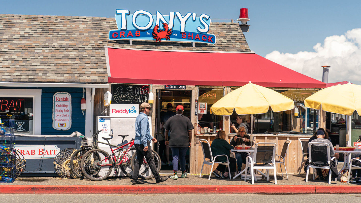 Restaurant exterior with outdoor seating and a sign that reads Tony's Crab Shack.