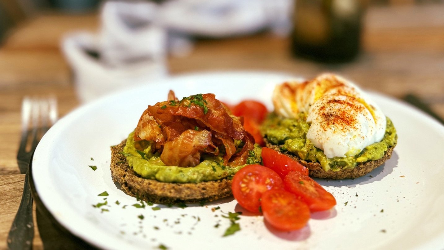 Eggs, bacon and avocado served on toasted bread.