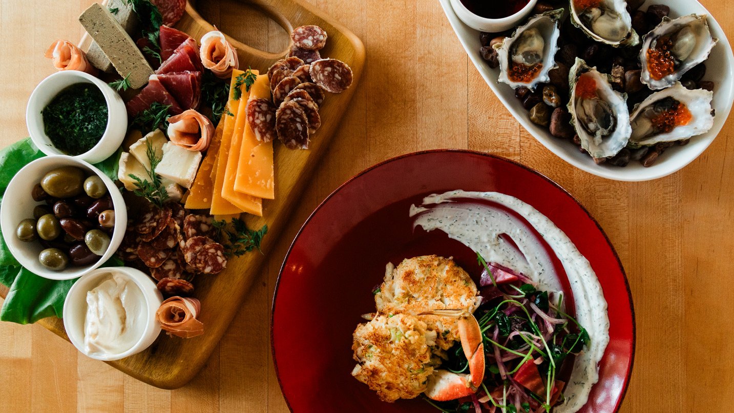 Plates of seafood and charcuterie on a table.