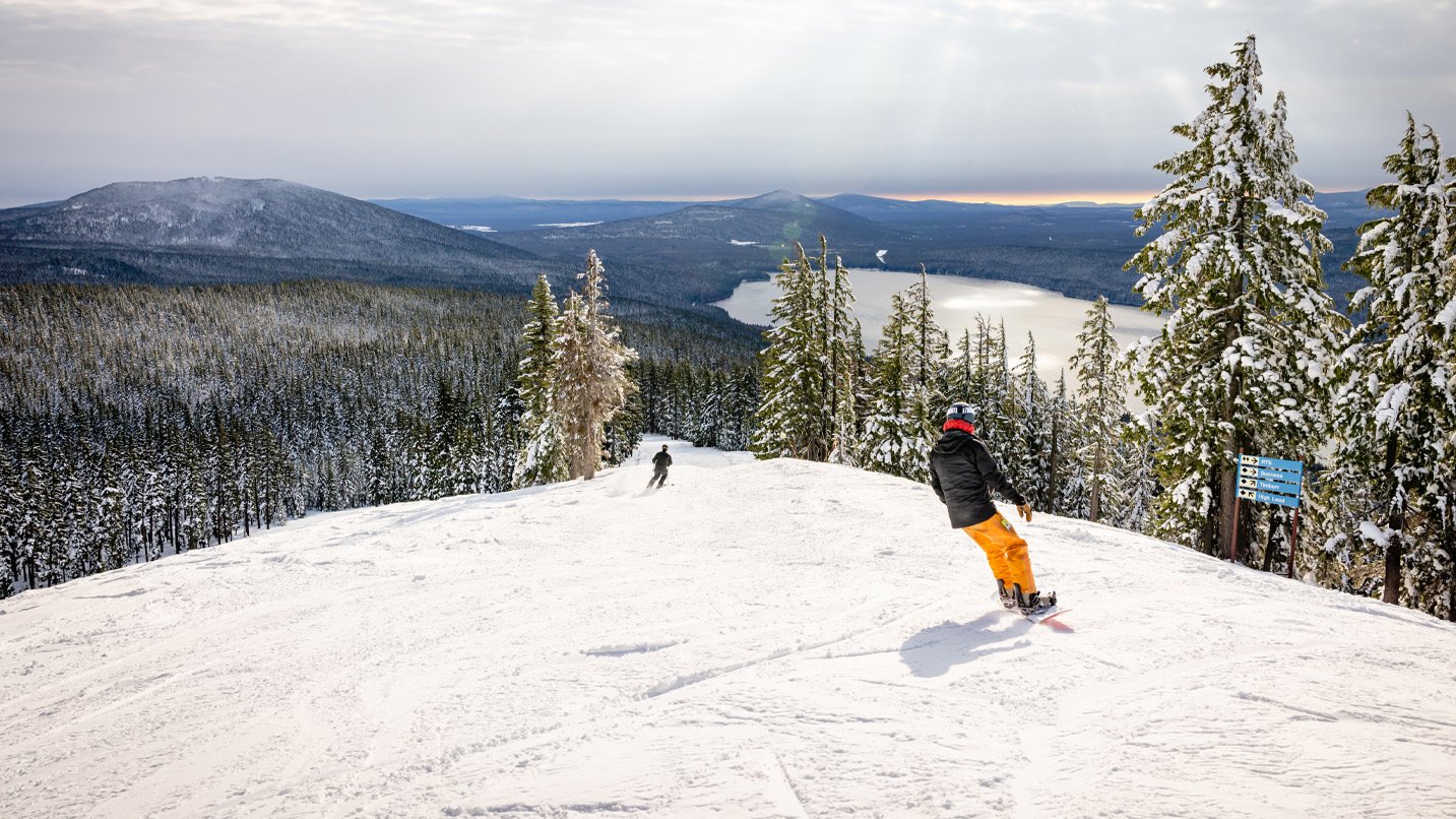 People snowboarding down a mountain.