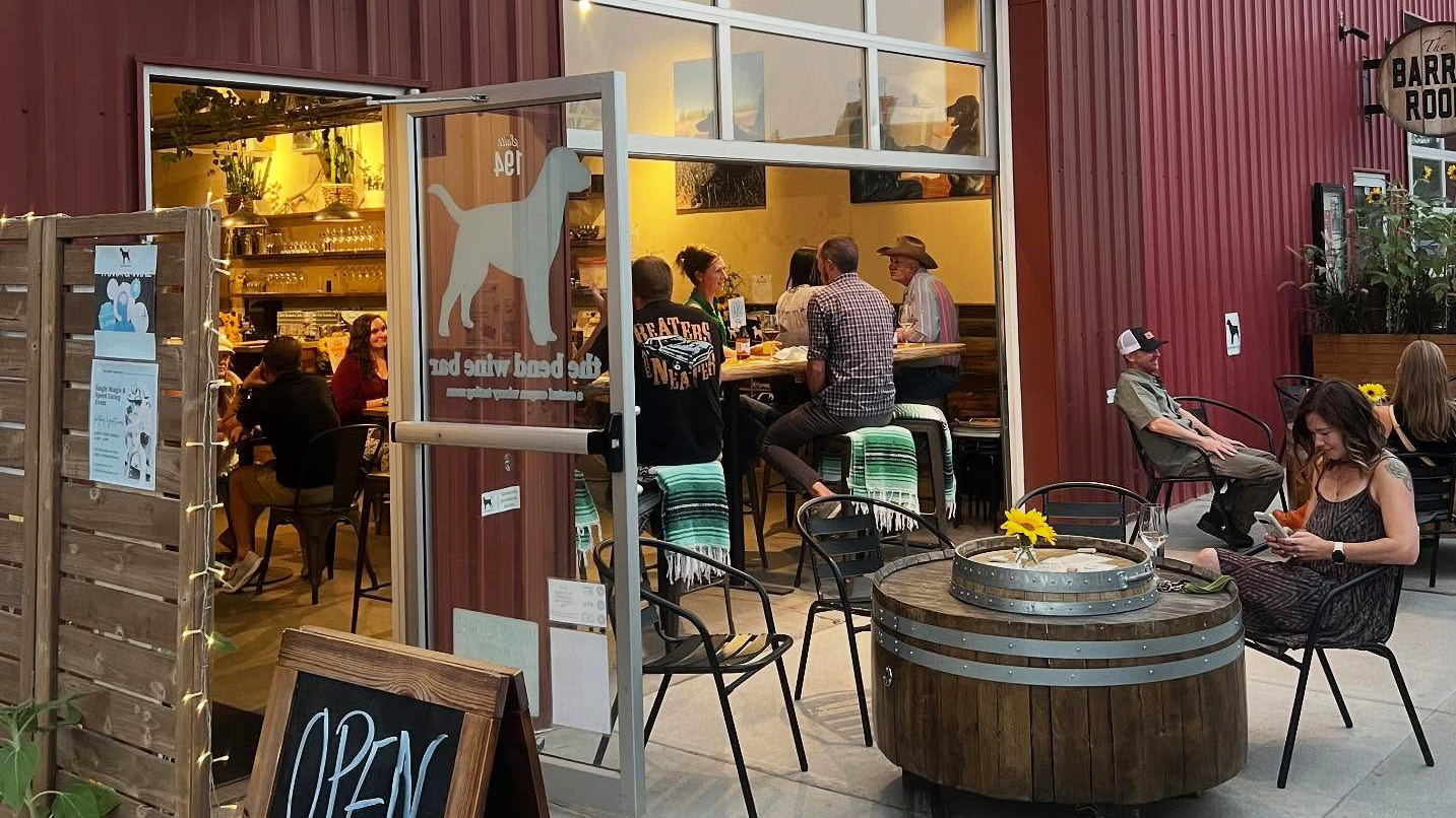 Exterior patio seating with several people around.