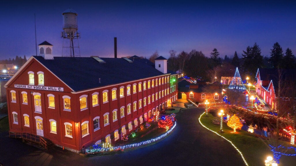 An aerial view of a historic building surrounded in holiday lights.