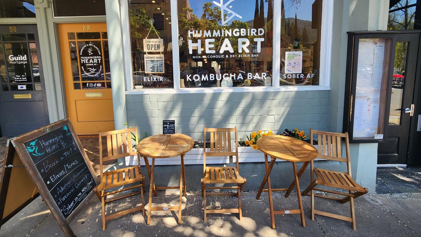 A welcoming facade with patio chairs on the sidewalk.