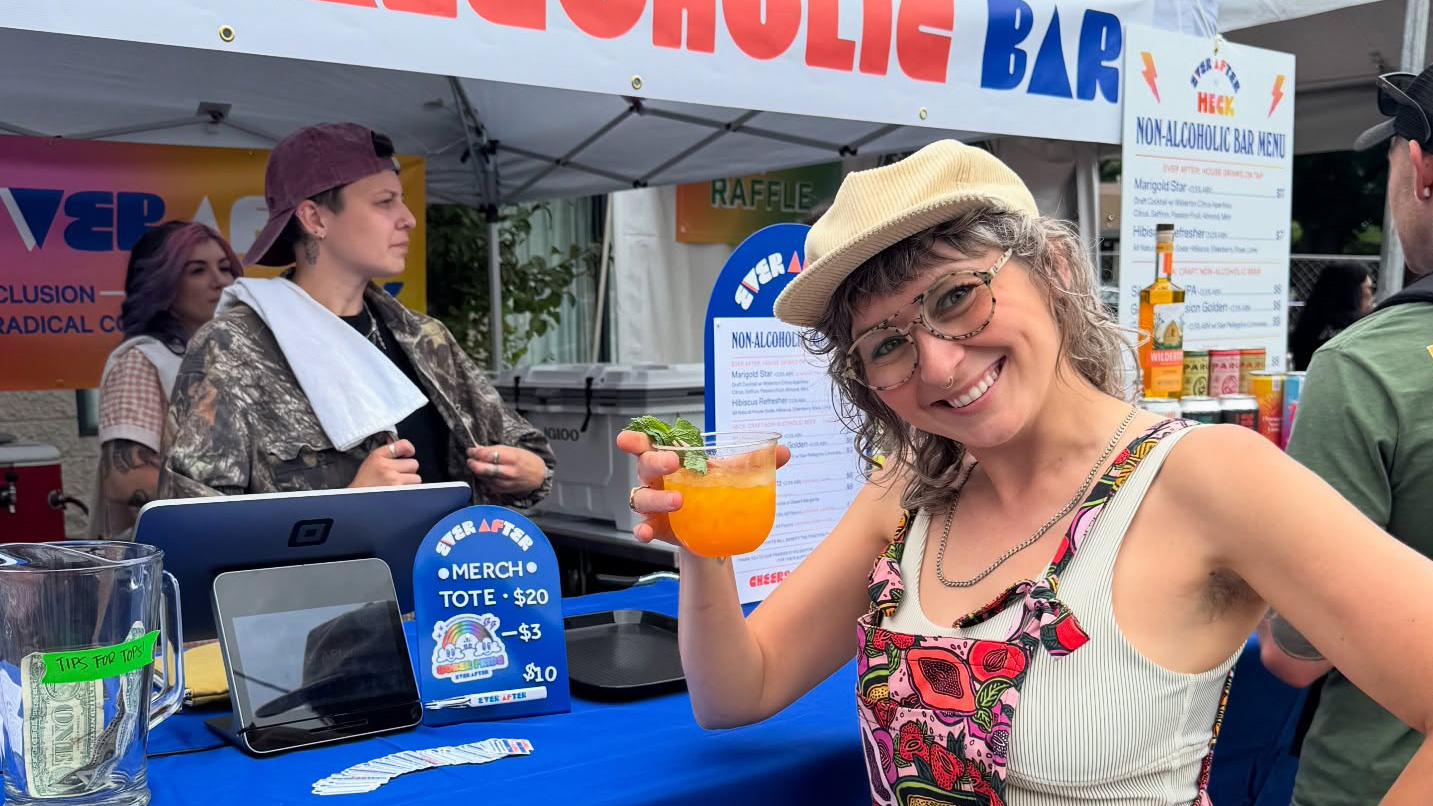 A person holds a drink in front of the camera.