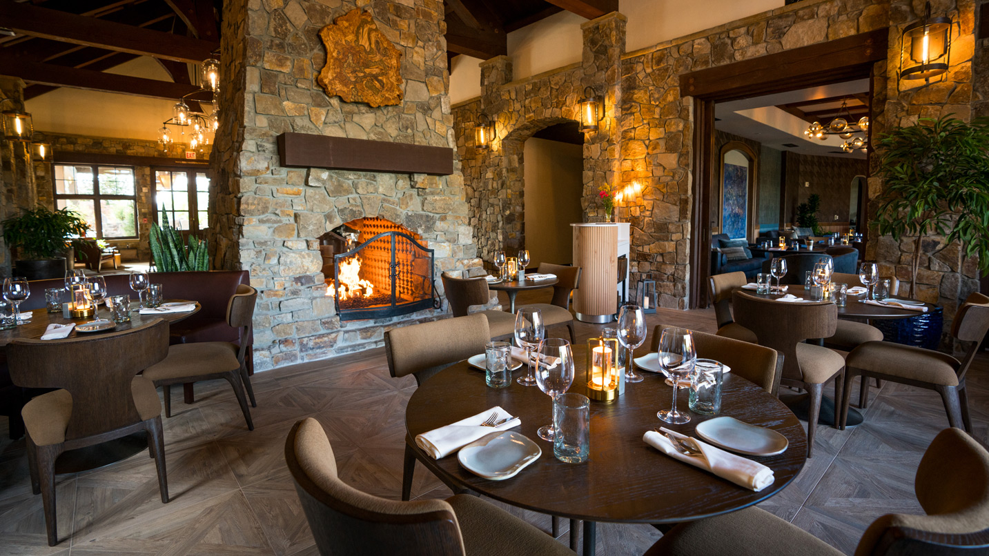 A warm dining room with a fire place.