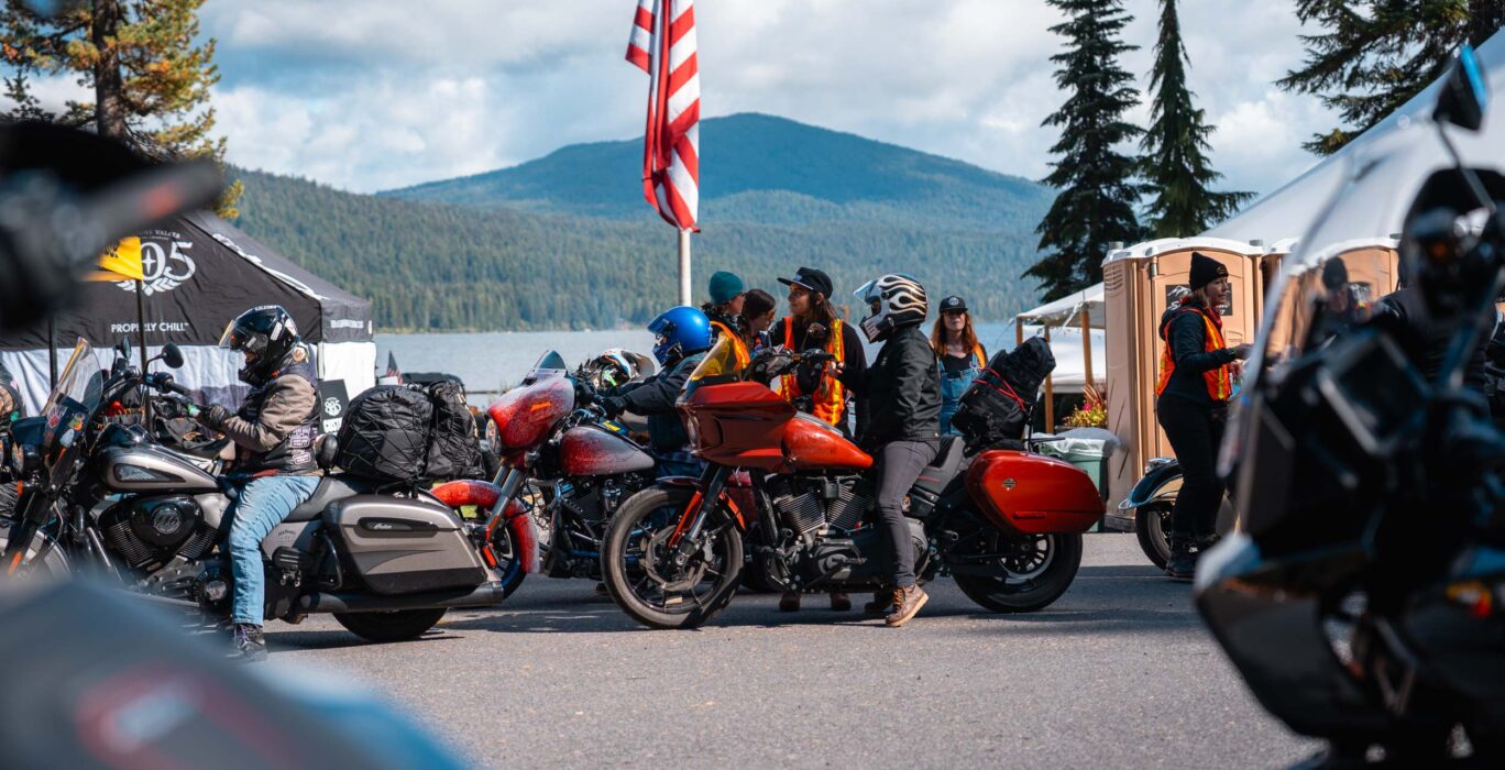 A group of women motorcyclists staged in front of Shelter Cove resort lake.
