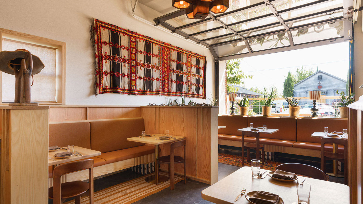 A garage-style door rolls up in a brightly-lit dining room