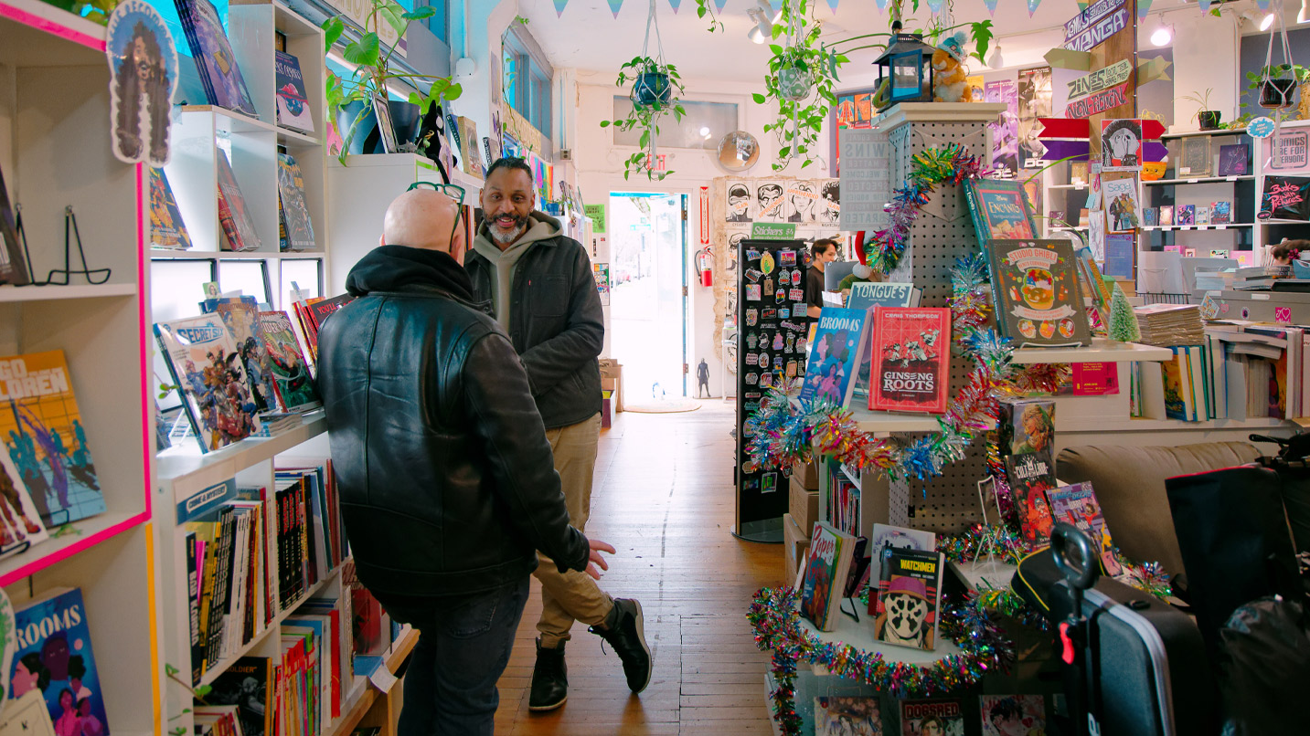 Two people talking inside a festive comic book store.