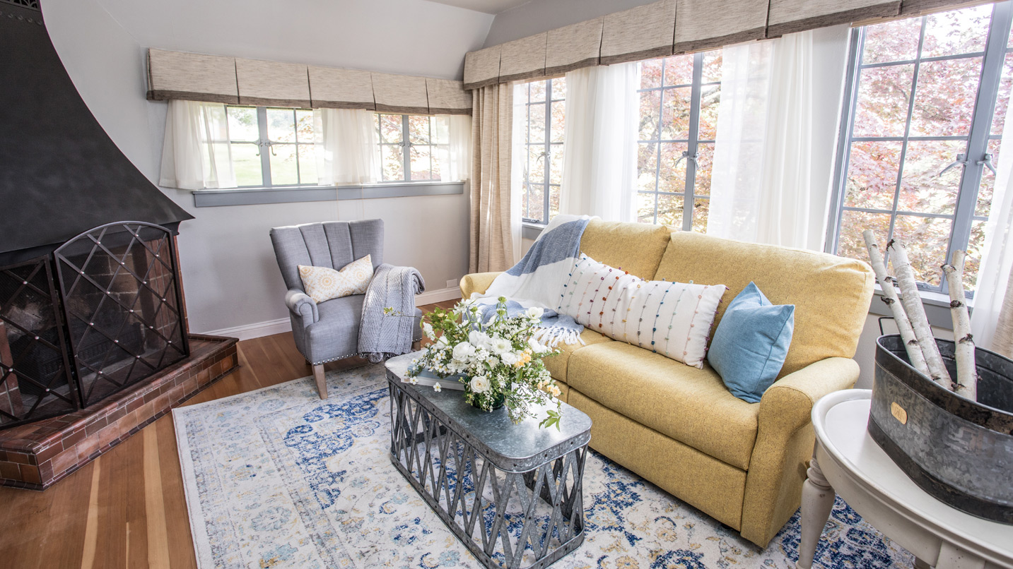 An indoor living room area decorated in soft blues, creams and yellows.