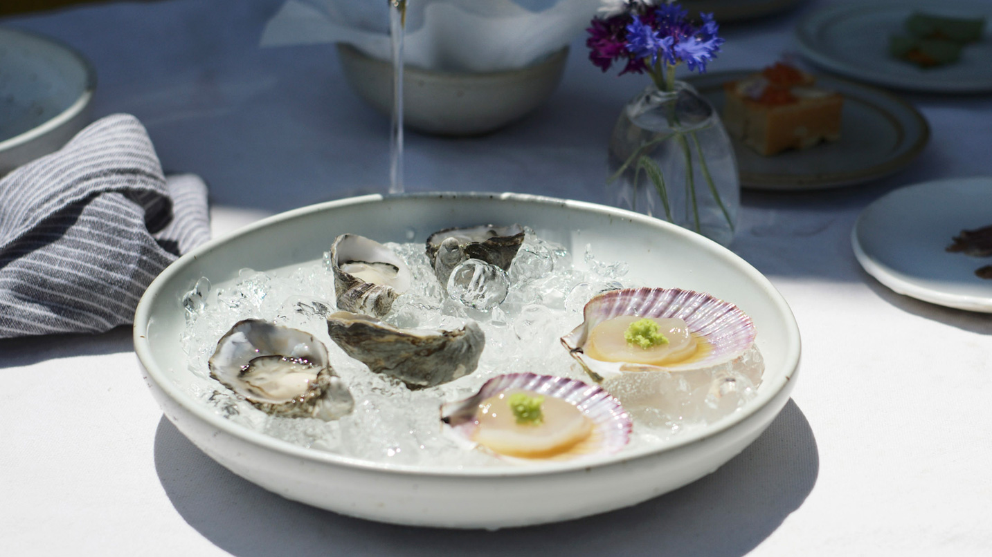 A plate of oysters and shellfish on a table.