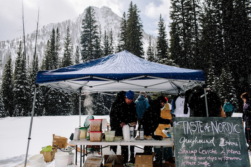 An outdoor kitchen in the snow offering tasting for the Taste of Nordic.,
