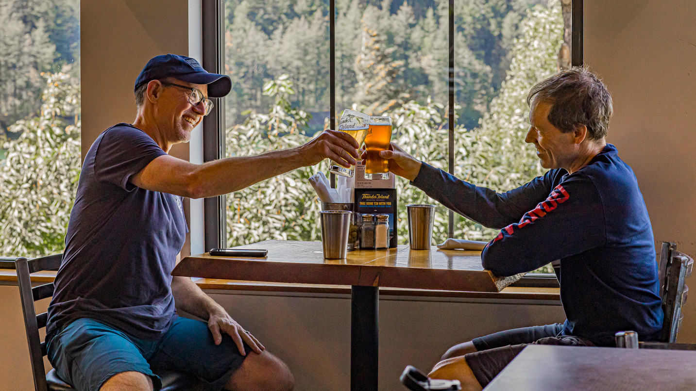 Two people cheersing with beers.