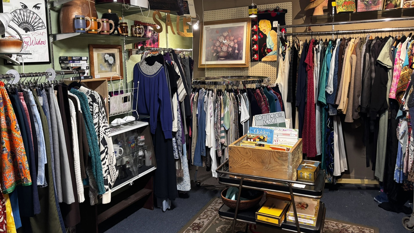 A tightly packed room with clothes, records and artwork.
