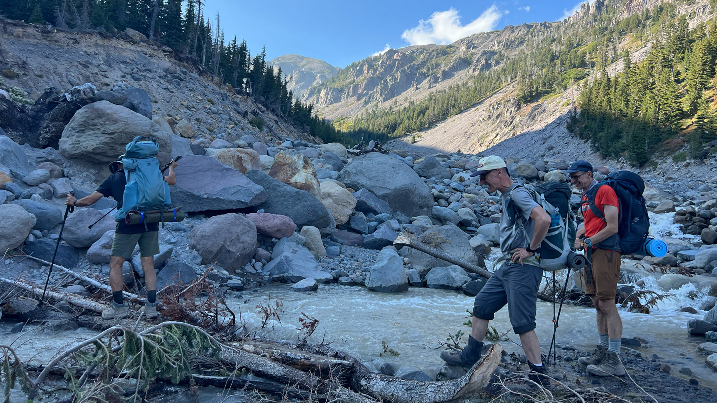 Backpackers crossing a river