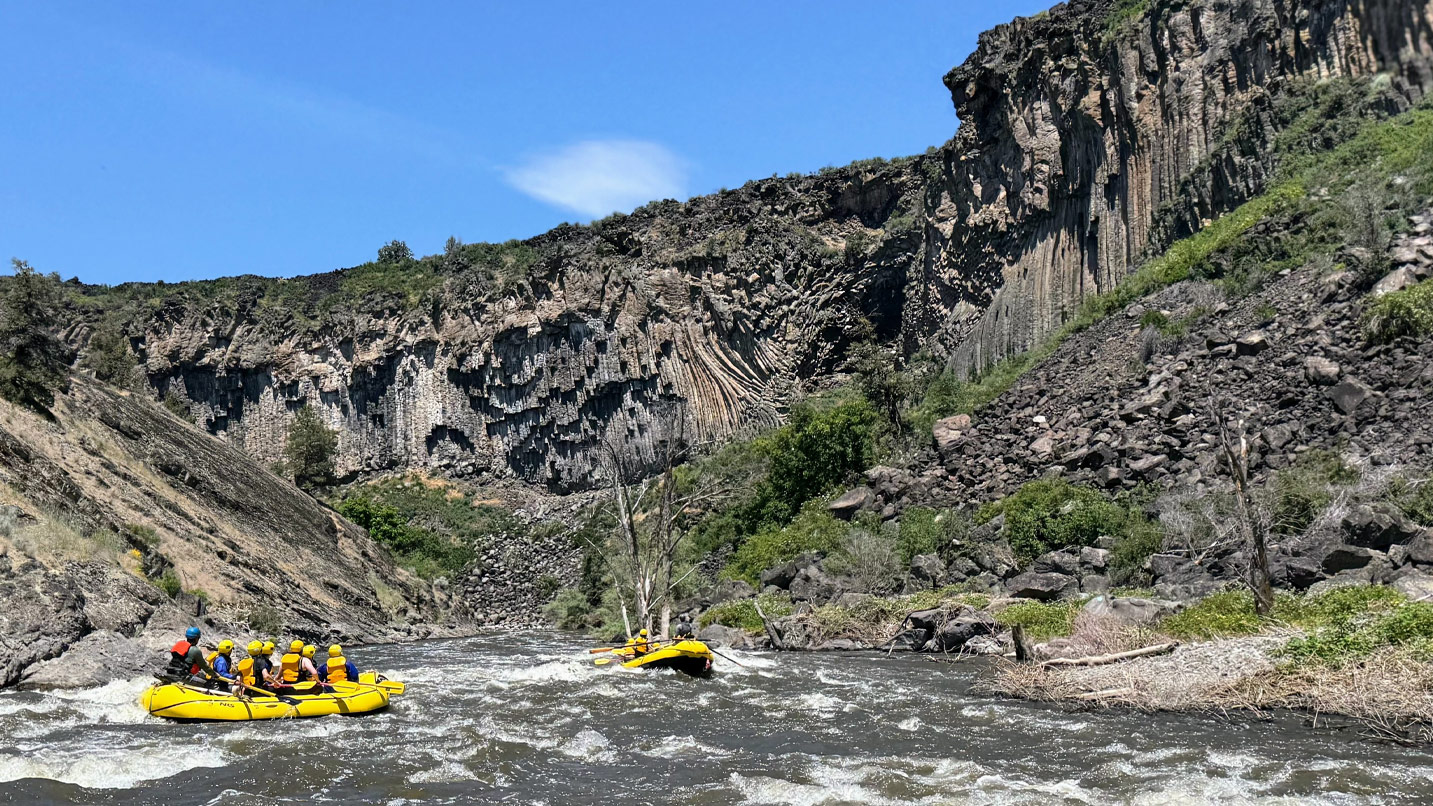 Rafters going through a narrow canyon.