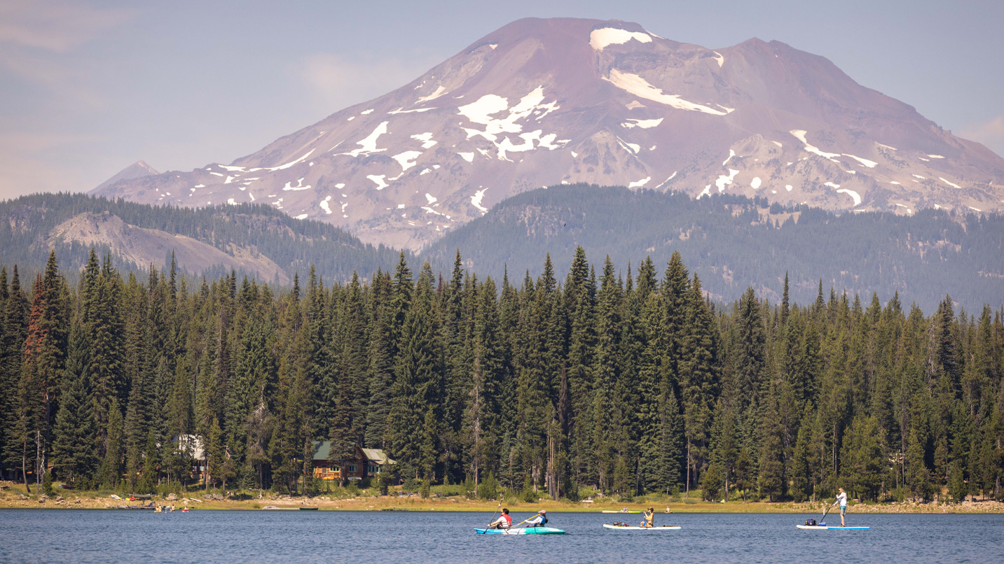 Kayaks on a lake with a mountain in the background.