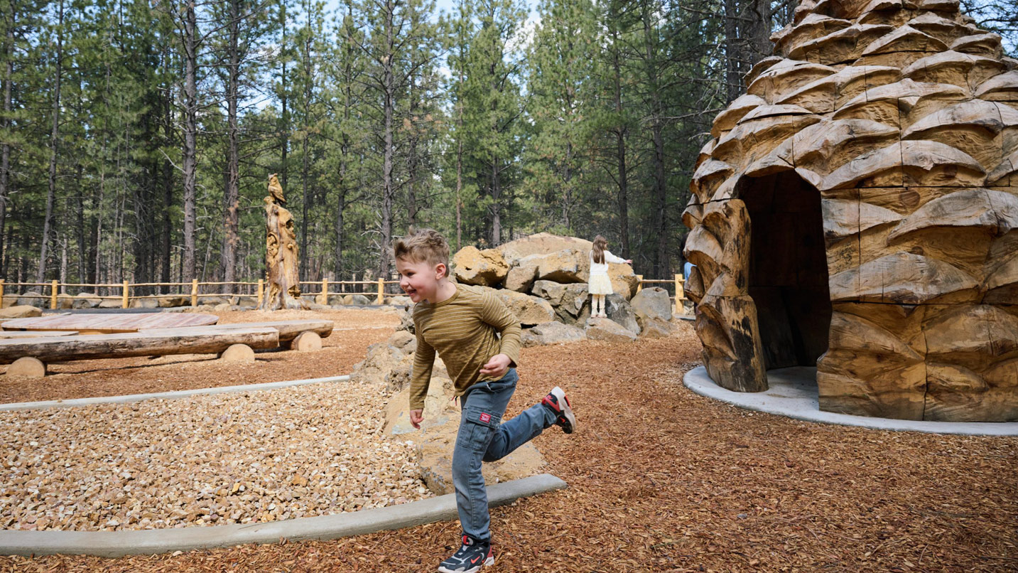 A male child running on a playground.