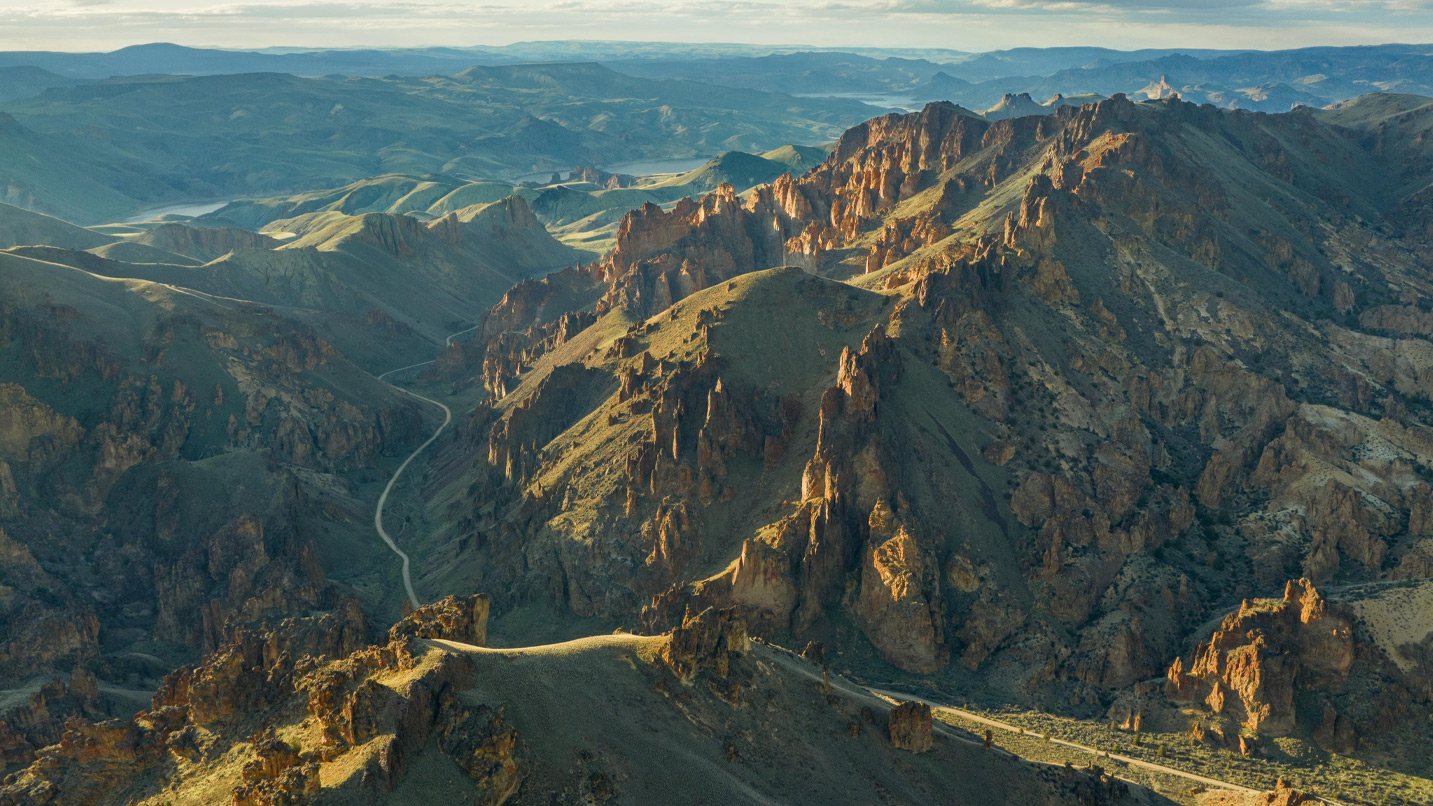 Aerial view of a curving road winding through the red rock canyons of Leslie Gulch.