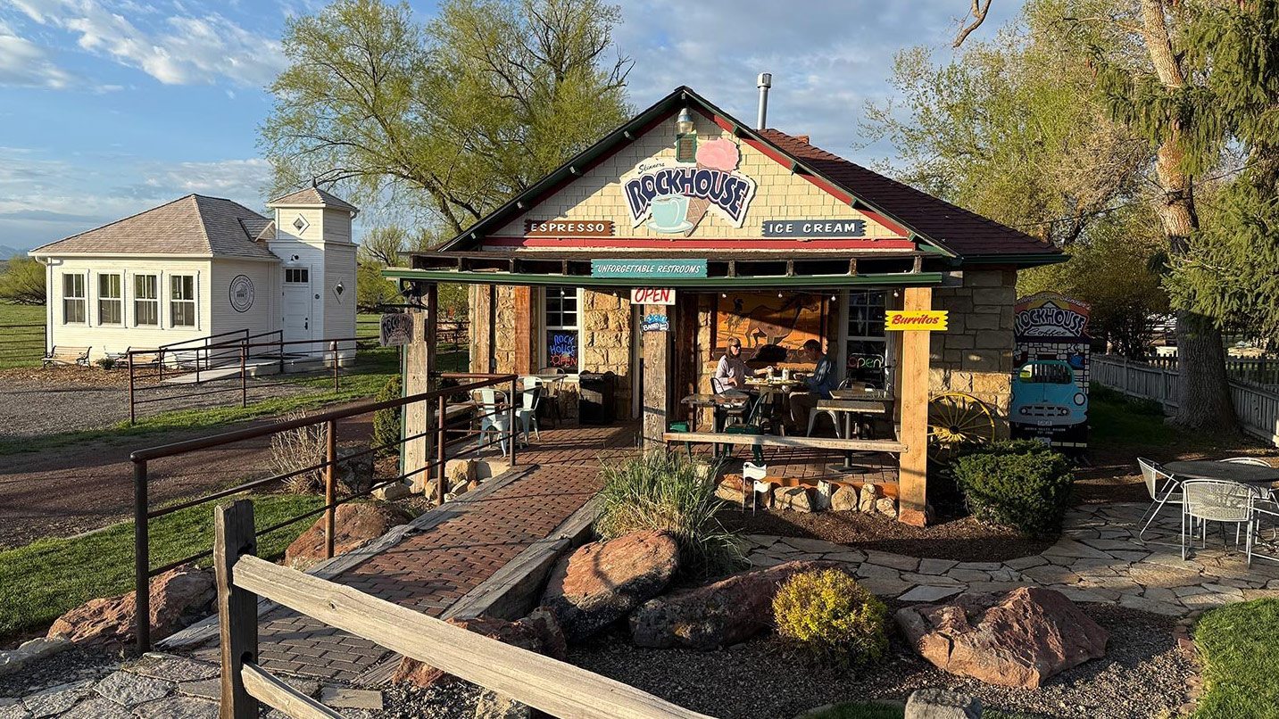 A small, standalone coffeeshop, with a large sign on its facade that reads Rockhouse.