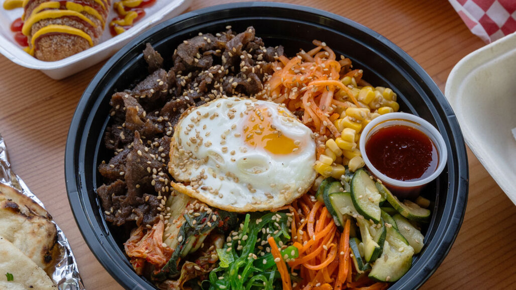 A Korean bibimbap bowl, filled with beef, egg, and pickled vegetables.
